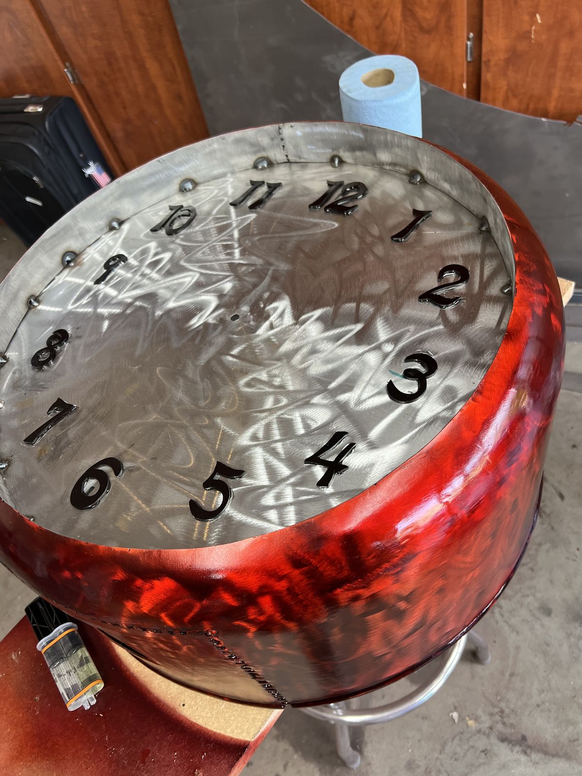 Clock face finished: swirled steel texture and a red rim.