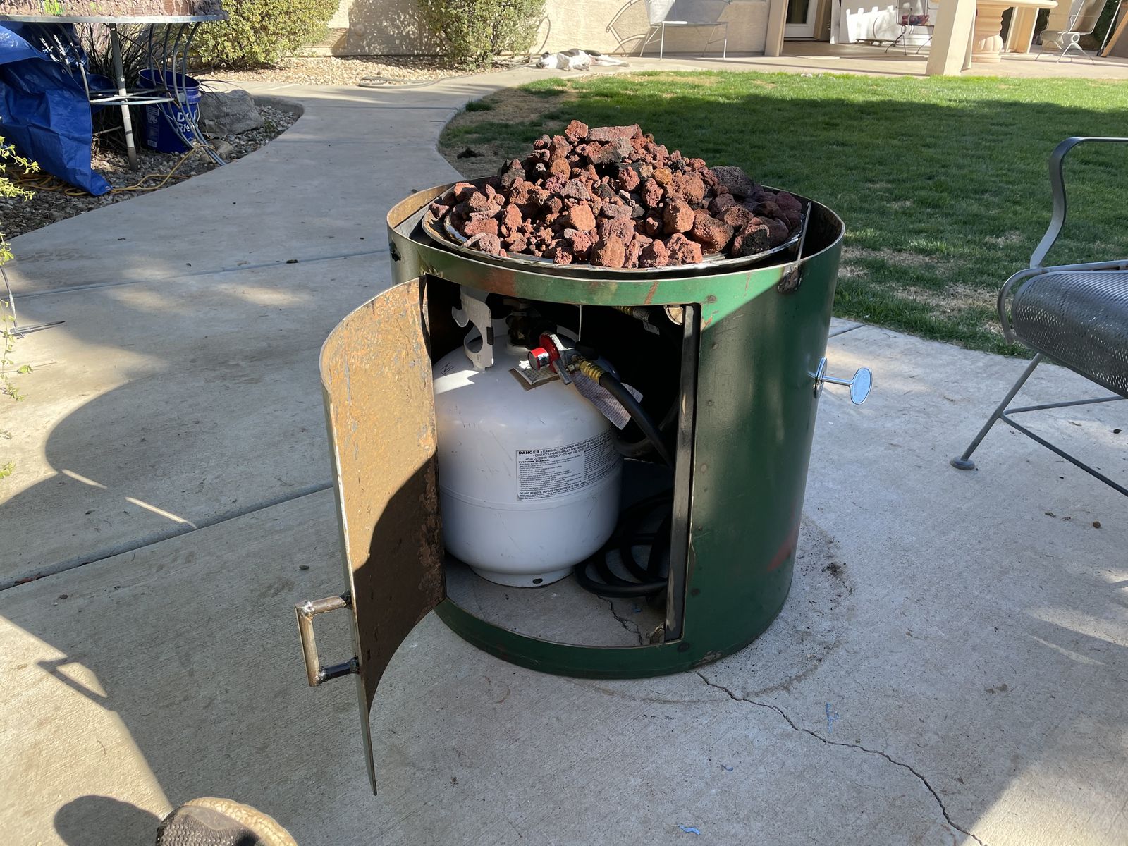 Assembled: lava rock in, propane tucked behind the door.