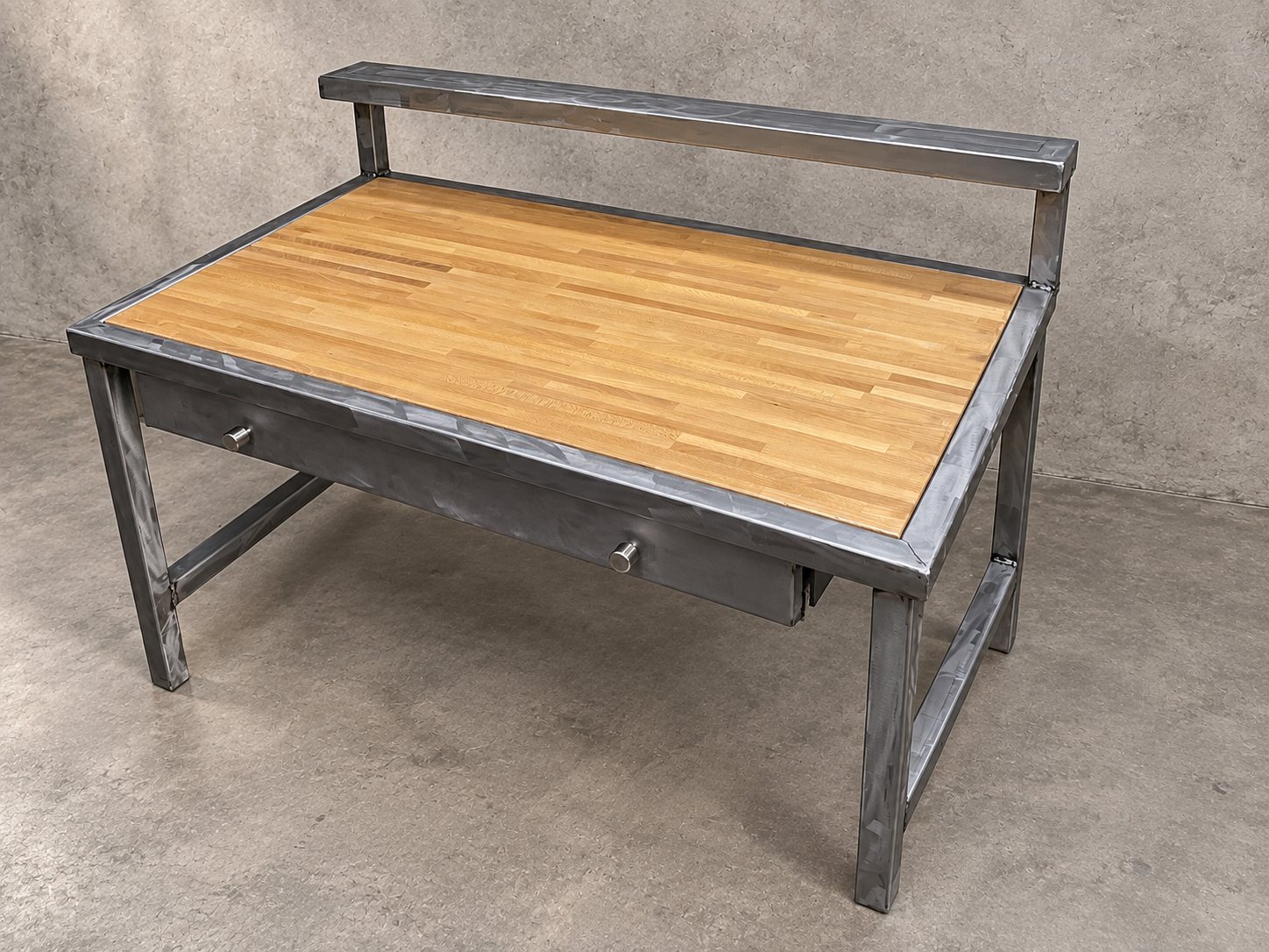 Steel-frame desk with butcher-block top, drawer, and raised back shelf
